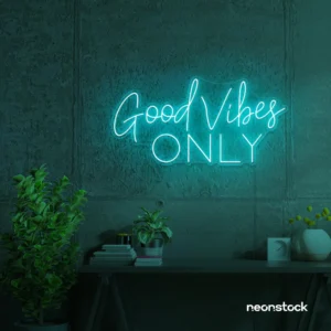Good Vibes Only neon sign glowing in mint green on a textured wall.