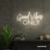 White neon sign spelling Good Vibes Only on a concrete wall.