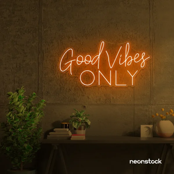 Orange neon Good Vibes Only sign glowing warmly in a room.
