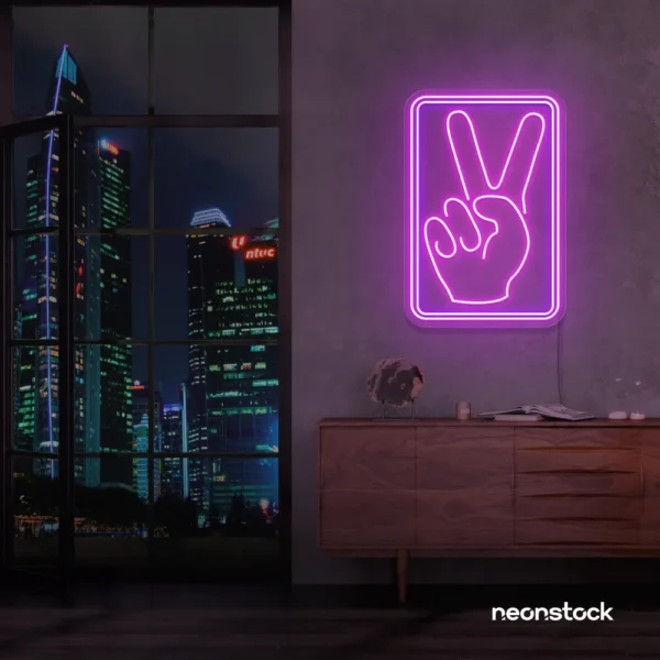 Purple neon peace hand sign mounted on a dark wall above a wooden cabinet.