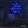 And So The Adventure Begins neon sign in dark blue for wedding decor, new beginnings, and celebration walls.