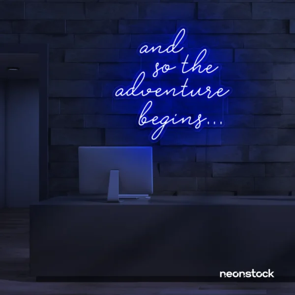 And So The Adventure Begins neon sign in dark blue for wedding decor, new beginnings, and celebration walls.
