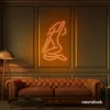 Sitting woman neon sign in orange for minimalist wall art and feminine home decor.