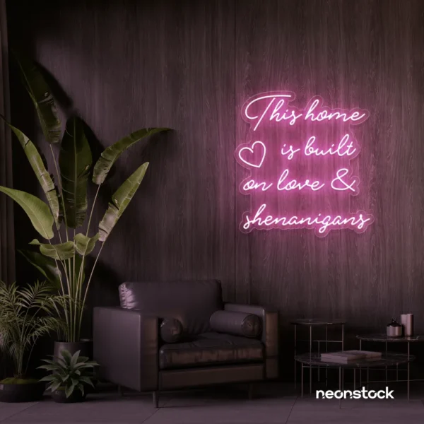 This Home Is Built on Love and Shenanigans neon sign in baby pink for family walls, living rooms, and cozy decor.