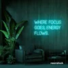 Where Focus Goes Energy Flows neon sign in mint green for productivity decor and creative inspiration.