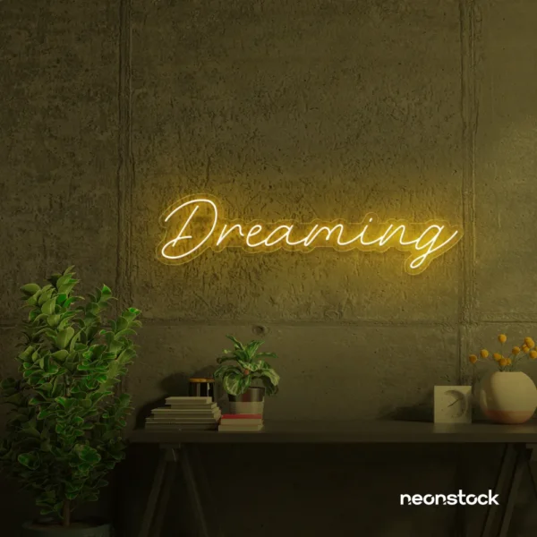 Dreaming neon sign in golden yellow for dreamy decor, teen bedrooms, and relaxing nooks.
