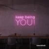 Keep Being You neon sign in baby pink for empowerment decor, teen rooms, and creative wall spaces.