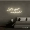 Let's Get Naked neon sign in neutral white for bathroom decor, cheeky bedrooms, and romantic lighting.