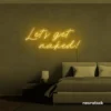 Let's Get Naked neon sign in golden yellow for bathroom decor, cheeky bedrooms, and romantic lighting.