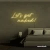 Let's Get Naked neon sign in warm white for bathroom decor, cheeky bedrooms, and romantic lighting.
