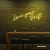 Love Yourself neon sign in mint green for self-love decor, beauty rooms, and empowering spaces.