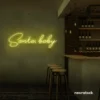 Santa Baby neon sign in lemon yellow for holiday parties, Christmas decor, and festive photo backdrops.