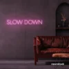 Slow Down neon sign in baby pink for relaxation spaces, wellness decor, and mindful interiors.