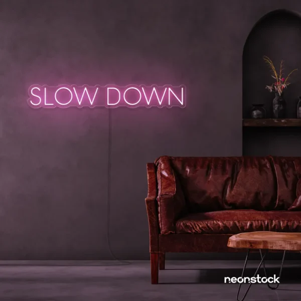 Slow Down neon sign in baby pink for relaxation spaces, wellness decor, and mindful interiors.