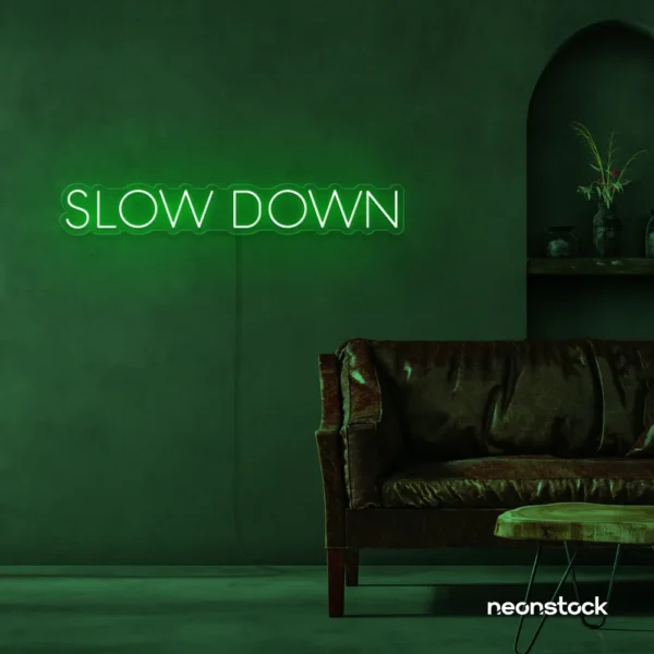 Slow Down neon sign in deep green for relaxation spaces, wellness decor, and mindful interiors.