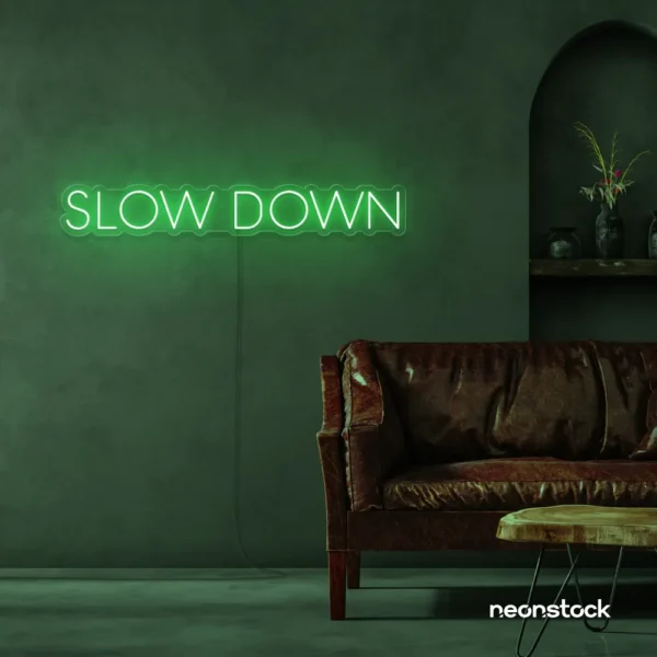 Slow Down neon sign in green for relaxation spaces, wellness decor, and mindful interiors.