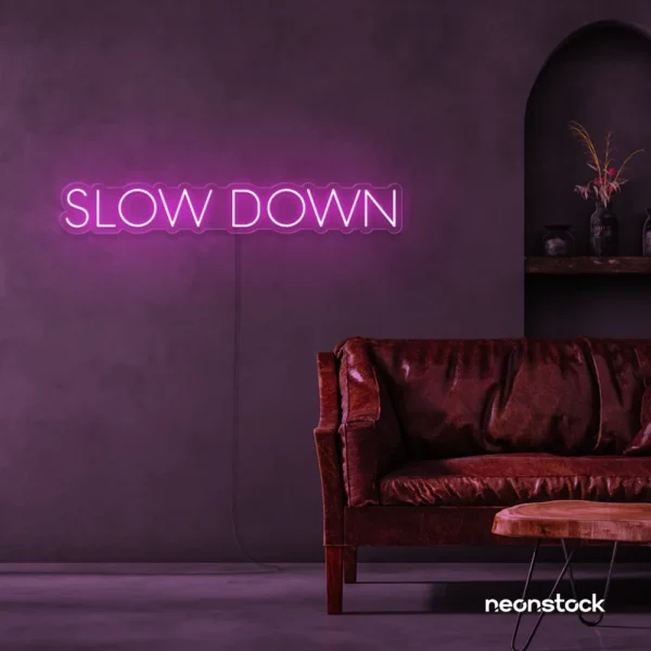 Slow Down neon sign in pink for relaxation spaces, wellness decor, and mindful interiors.
