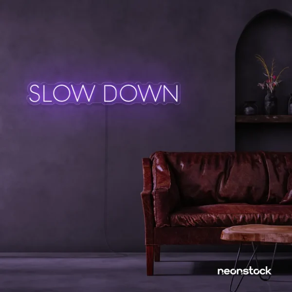 Slow Down neon sign in purple for relaxation spaces, wellness decor, and mindful interiors.