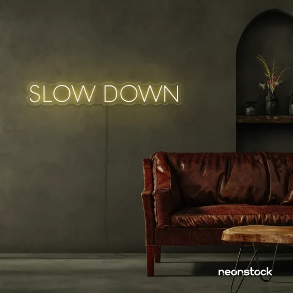 Slow Down neon sign in warm white for relaxation spaces, wellness decor, and mindful interiors.