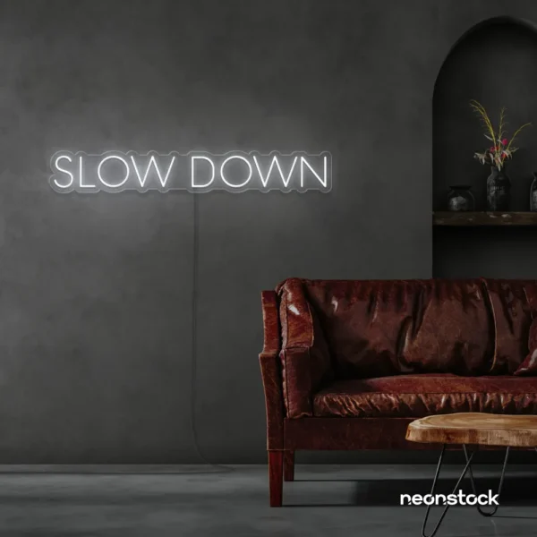 Slow Down neon sign in white for relaxation spaces, wellness decor, and mindful interiors.