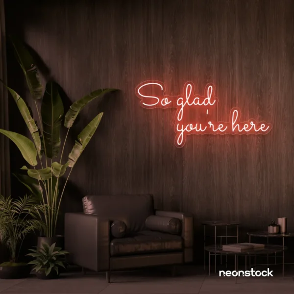 So Glad You Are Here neon sign in peachy pink for entryways, restaurant walls, and welcoming interiors.