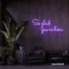So Glad You Are Here neon sign in purple for entryways, restaurant walls, and welcoming interiors.