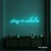 Stay Awhile neon sign in mint green for cozy cafes, home decor, and hospitality settings.