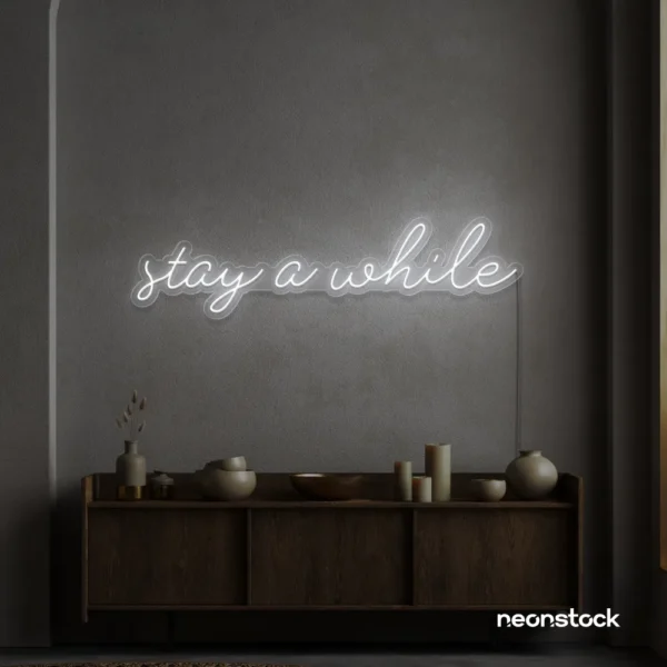 Stay Awhile neon sign in white for cozy cafes, home decor, and hospitality settings.