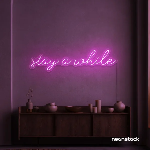 Stay Awhile neon sign in pink for cozy cafes, home decor, and hospitality settings.