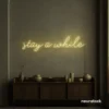 Stay Awhile neon sign in warm white for cozy cafes, home decor, and hospitality settings.