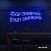 Stop Thinking Start Drinking neon sign in dark blue for bar walls, man caves, and party spaces.