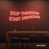 Stop Thinking Start Drinking neon sign in peachy pink for bar walls, man caves, and party spaces.
