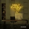 Take It Easy neon sign in golden yellow for chill wall decor, boho rooms, and relaxed interiors.