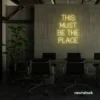 This Must Be The Place neon sign in warm white for cozy salons, boutique shops, and cafe decor.