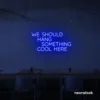 Neon sign text 'We should hang something cool here' in dark blue for wall art and home decor