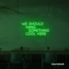 Neon sign text 'We should hang something cool here' in deep green for wall art and home decor