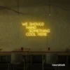 Neon sign text 'We should hang something cool here' in golden yellow for wall art and home decor