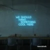 Neon sign text 'We should hang something cool here' in ice blue for wall art and home decor