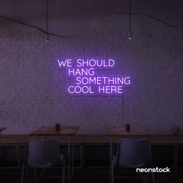 Neon sign text 'We should hang something cool here' in purple for wall art and home decor
