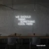 Neon sign text 'We should hang something cool here' in white for wall art and home decor