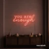 You Are Enough neon sign in peachy pink for self-love decor, therapy rooms, and calm spaces.